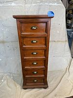 Full front view showing 7 drawers with brass cup pull handles and overall condition of wood surface.