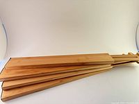 Four bamboo drawer dividers stacked horizontally showing smooth wooden finish and natural color.