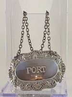 Front view of the silver plated decanter label with ornate detailing and 'PORT' engraving