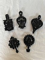 Top view of all five unique cast iron trivets arranged in a group