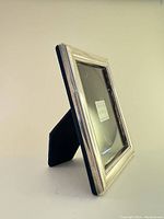 Side angle showing velvet backing and fold-out stand for tabletop display