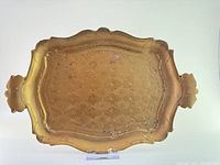 Top view of the gilt wooden tray showing the floral patterned surface, scalloped edges, and handles.