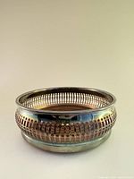 Side profile showing silver-plated exterior with reticulated sides and rounded shape.