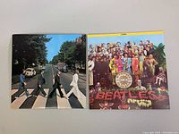 Photo showing front covers of the two Beatles vinyl records, Abbey Road on left and Sgt. Pepper's Lonely Hearts Club Band on right.