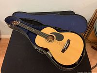 Full view of the guitar inside the hard case, showing the guitar body, neck, and case interior.