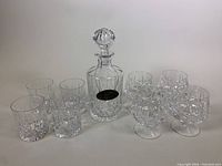 Full set of one crystal decanter with stopper and 8 glasses (4 old fashioned, 4 brandy) displayed.