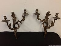 Pair of brass 2-arm wall sconces with elaborate leaf design, side view
