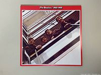 Front cover of The Beatles 1962-1966 red double vinyl album showing band members looking down from railing