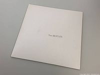 Closed white cover of The Beatles White Album with minimal black text.