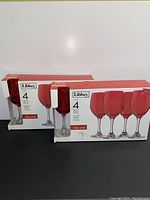 Two unopened boxes of Libbey ruby wine glasses each containing 4 glasses for total of 8 glasses.