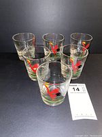 Five clear vintage Federal lowball glasses arranged in a group, each featuring a red rooster with black tail and yellow comb standing on green grass design.
