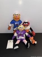 Photo of three NHL Muppets plush dolls grouped together, showing details of their jerseys and helmets.