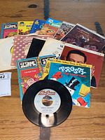Overhead image showing seven children's 45 RPM records with illustrated sleeves featuring Frosty the Snowman, Sesame Street, Frank Sinatra, and Charlie Brown.