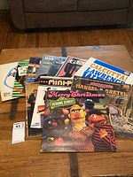 Table displaying a spread of vinyl record album covers showing children and adult records including Sesame Street Merry Christmas and Hansel and Gretel.