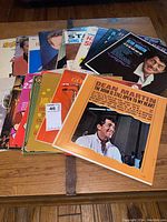 Several vinyl LP records stacked including the top cover of Dean Martin's album 'The Door Is Still Open To My Heart'