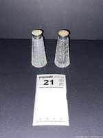 Front view showing the pair of cut crystal salt and pepper shakers with mother of pearl tops.