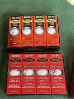 Four boxes of golf balls, clearly showing Top Flite XL 2000 Super Titanium branded boxes with 3 golf balls visible inside each box.