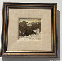 Frontal photograph of the oil painting set in gold tone frame. Visible winter mountain landscape with snow and hills.