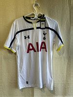 Front view of white Tottenham Hotspur FC 2014-2015 home jersey with logos and tags visible.