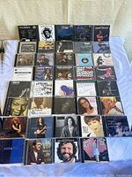 Photo of 40 music CDs laid out in rows, showing album covers and jewel cases.