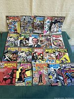 Photo showing 20 Marvel Age comic books from 1987 arranged with covers facing up. Various issues including 85, 86, 64, 83, 89 visible with colorful 1980s Marvel artwork.
