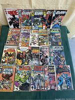 Twenty comics laid out in four rows of five on green cloth