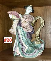 Front view of Fitz & Floyd ceramic pitcher showing an Asian woman holding a fan, with detailed colorful attire and gold accents, 11 inches tall.