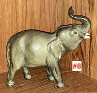 Elephant figurine side angle showing trunk raised and detailed texture.