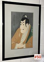 Straight-on view of framed Japanese woodblock print showing stylized portrait of a man in kimono.