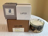 Group of four candles: three boxed and one unboxed glass vessel