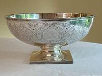 Front view of sterling silver pedestal bowl showing engraved floral and scroll decoration