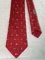 Full view of red silk tie laid flat showing overall pattern and shape