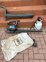 Full view of Toro Super Blower Vac parts including blower tube, main unit, and collection bag along with handheld lawn sprayer.