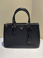 Front view of black Prada Galleria bag with handles upright