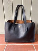 Front view showing navy pebbled leather exterior and gold-tone RL plaque