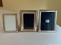 Front view of all three sterling silver picture frames displayed side by side.