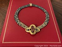 Full view of beaded choker necklace on red background