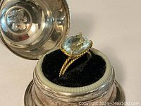 Ring displayed in open box on black velvet insert