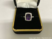 Front view of ring in box showing amethyst center and diamond halo
