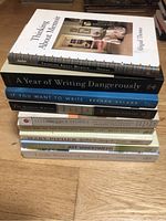 Stack of ten books about writing and memoir on a wooden surface