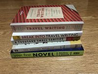 Photo showing five stacked books with titles Travel Writing, Break Into Travel Writing, A Thousand Small Sanities, The Weekend Novelists, and Your First Novel by Pittsberg & Whitcomb.