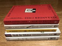 Stack of four books about writing with titles visible on spines, placed on wooden surface.