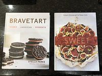 Photo showing both Bravetart and Sweet cookbooks side by side on a dark surface.