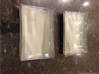 Top view of two Japanese handmade square ceramic plates with a natural glazed finish showing size difference