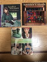 Three knitting books displayed on wooden surface. Titles: 'handknit HOLIDAYS', 'knitter's stash', and 'TWELVE MONTHS OF KNITTING' with images of knitwear on covers.