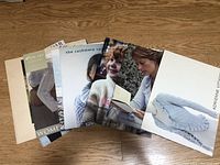 Six knitting pattern booklets laid out side by side showing adult and child designs