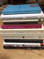 Stacked pile of 11 nonfiction books with visible titles and authors on bindings