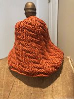 Orange hand knit cowl displayed on mannequin, showing overall shape and knit texture.