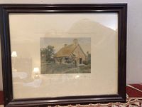 Framed colored photo of a stone cottage with thatched roof and garden, titled and signed by Wallace Nutting.
