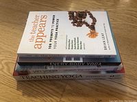 Stack of four yoga books shown from the side, titles visible on spines.